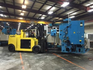 A yellow forklift is parked in an empty warehouse.