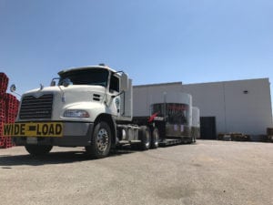 A white truck is parked in front of a building.