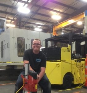 A man sitting in front of a yellow truck.