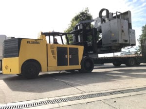 A large yellow and black truck is pulling a trailer.