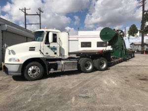 A large white truck with a green trailer.