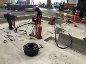 A man is working on the floor of an indoor area.