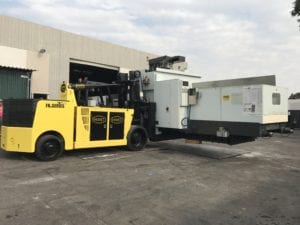 A yellow forklift is loading a white truck.