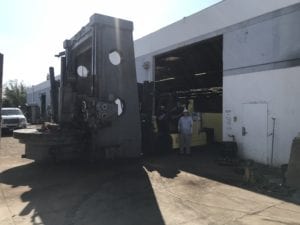 A man standing in front of an industrial building.