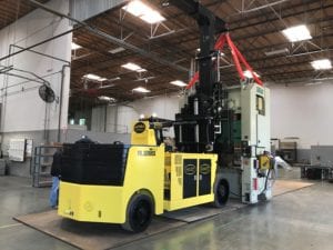 A yellow forklift is parked in the middle of an industrial area.