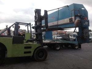 A large truck is being loaded with a trailer.