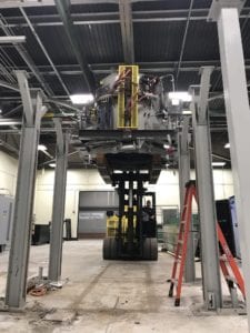 A large machine in an industrial setting with some people.