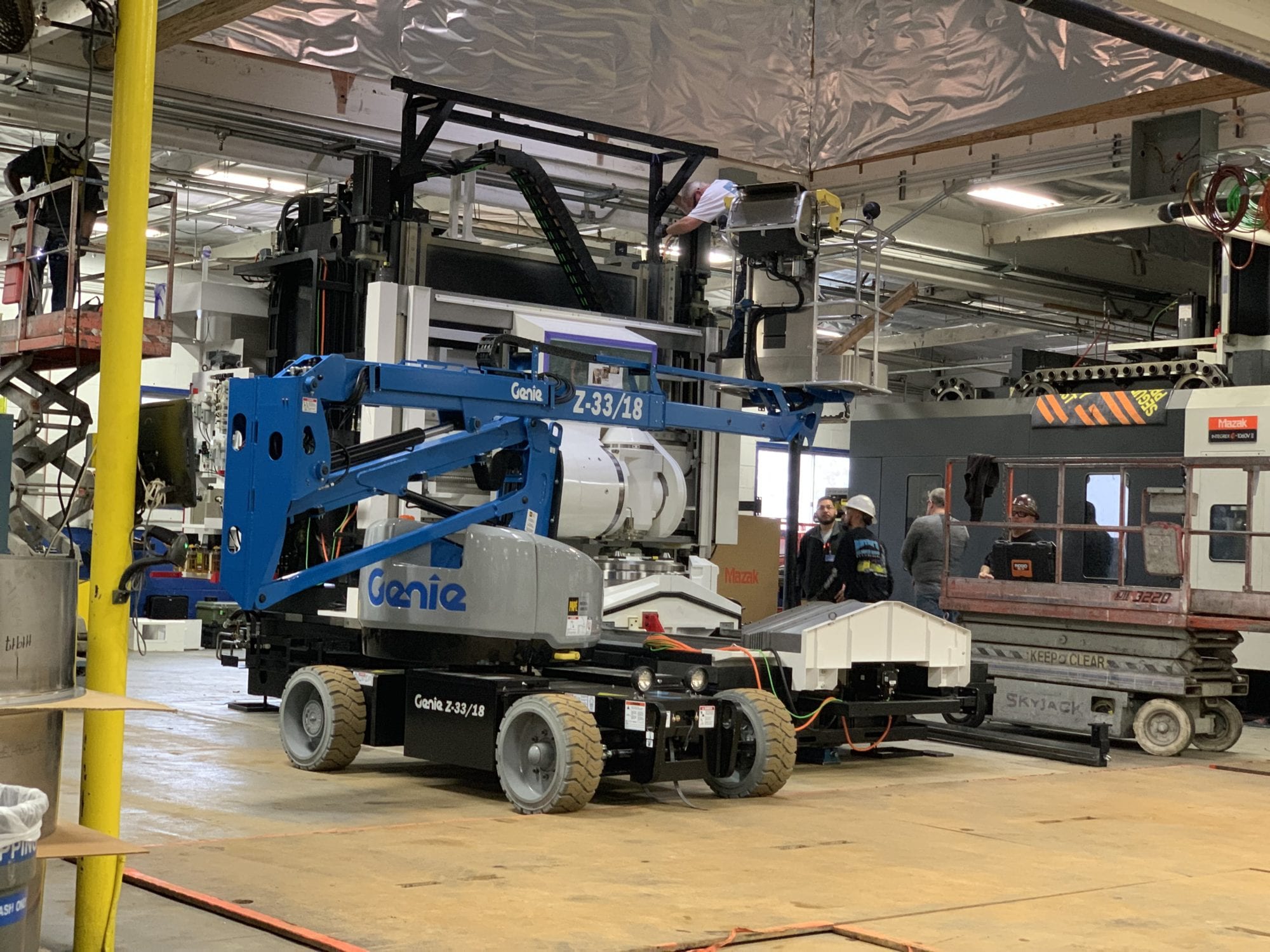 A blue and white crane truck in a warehouse.