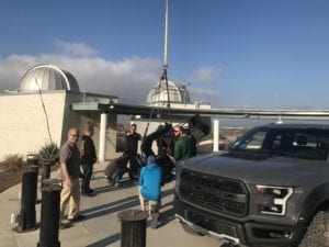 A group of people standing around a truck.