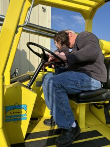 Man and child in yellow vehicle.