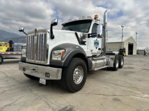 White semi-truck parked on concrete lot.