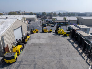 Industrial yard with yellow machinery and buildings.