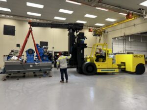 Warehouse workers operating heavy machinery indoors.