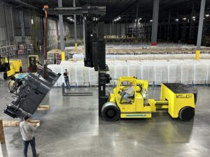 Yellow forklift lifting equipment in warehouse.