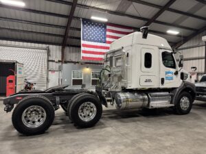 Truck parked inside garage with American flag.